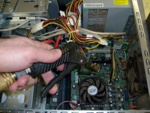 Dan holding high pressure air nozzle inside PC, to blow out the dust bunnies.