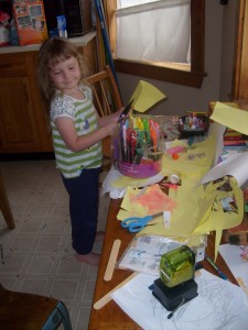 K's desk covered in new paper cut with fancy edged scissors