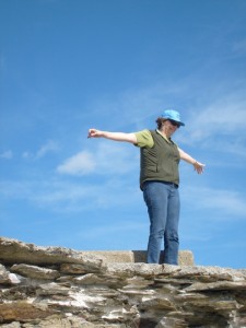 Aunt B at Beavertail Lighthouse rocks, spreading her arms to the wind and the sunshine