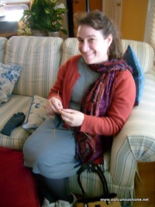 Christine Guest knitting a glove on her mom's couch