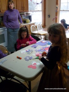 K and a friend glueing die cut hearts into animals