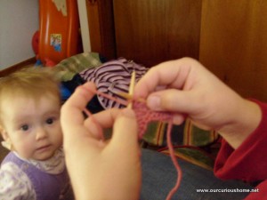 Christine's hands as she begins a tutorial photo shoot of the Christmas Tree Increase while baby K plots to grab the needles in the background