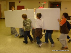 Kids putting a table away at Eagle's Wings coop