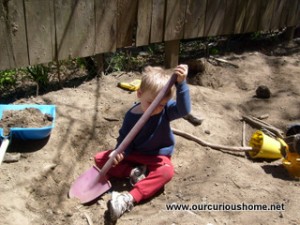 M playing in the dirt at the side yard