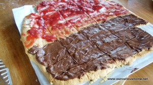 gf sugar cookie baked as pizza, topped half with formage blanque, strawberry jam, and half with nutella.