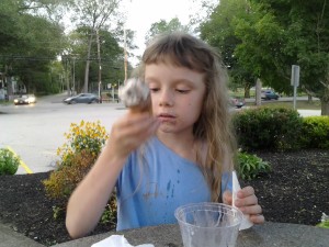 K preparing to bite the bottom of her ice cream cone