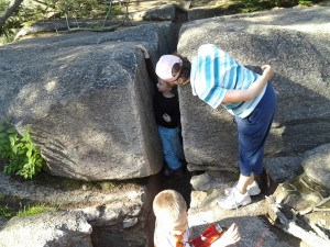 My Mom peeking into the rock crevise K is climbing in