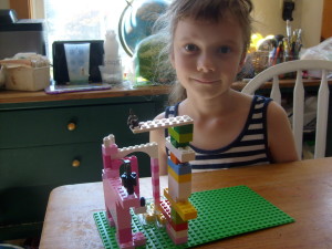 K behind her pink Lego frog eating a fly while firing a bazooka at a kitten. I hope it missed the kitten, but it's welcome to the frog.