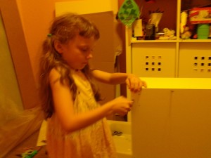 K helping to build one of the pieces of furniture