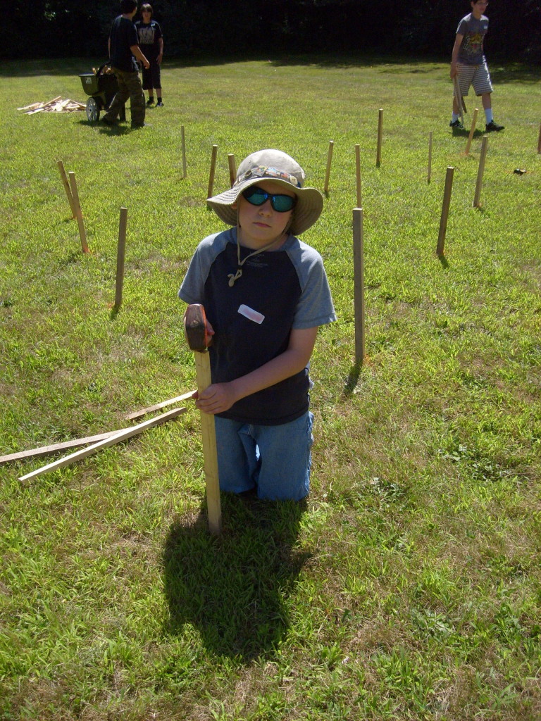 M pounds a stake into the ground