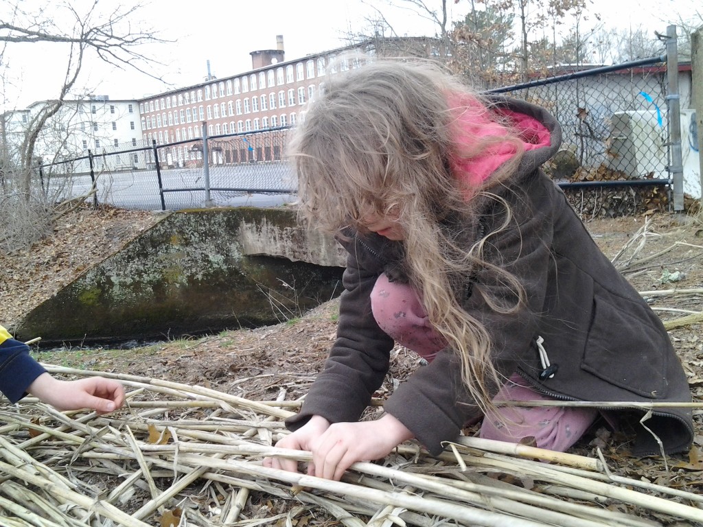 K continues to work on the reed mat raft.