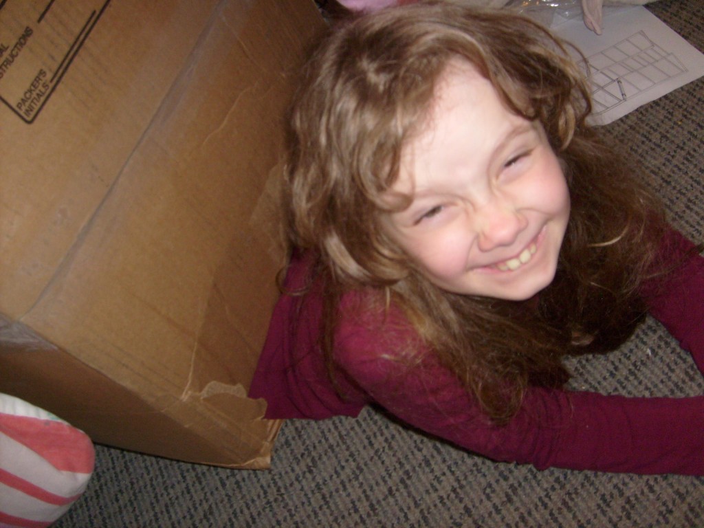 K grinning as she crawls out of her box