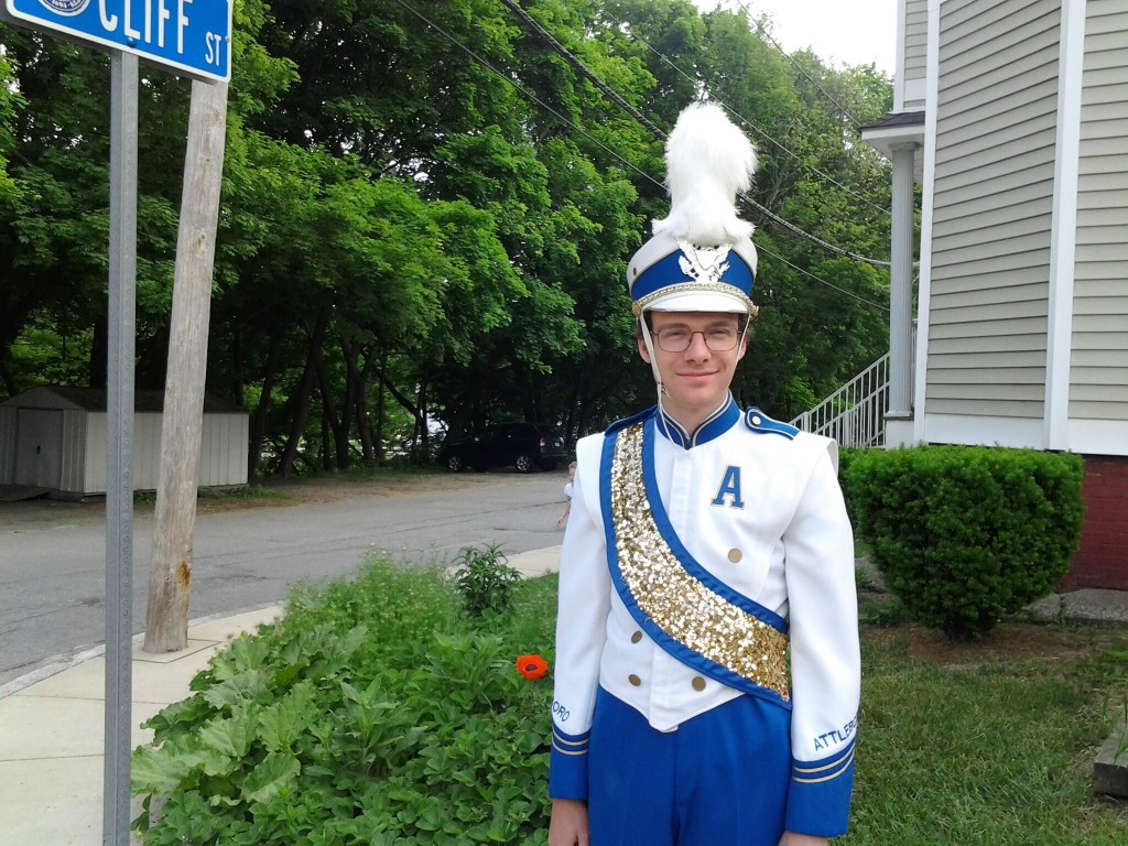 Ben in Band Uniform with Plume in the front garden when the poppy was blooming