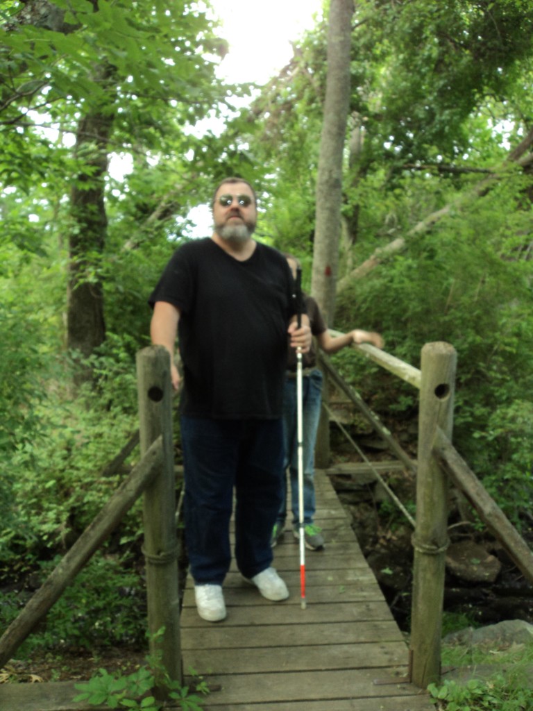 Warren ane walking across a narrow foot bridge