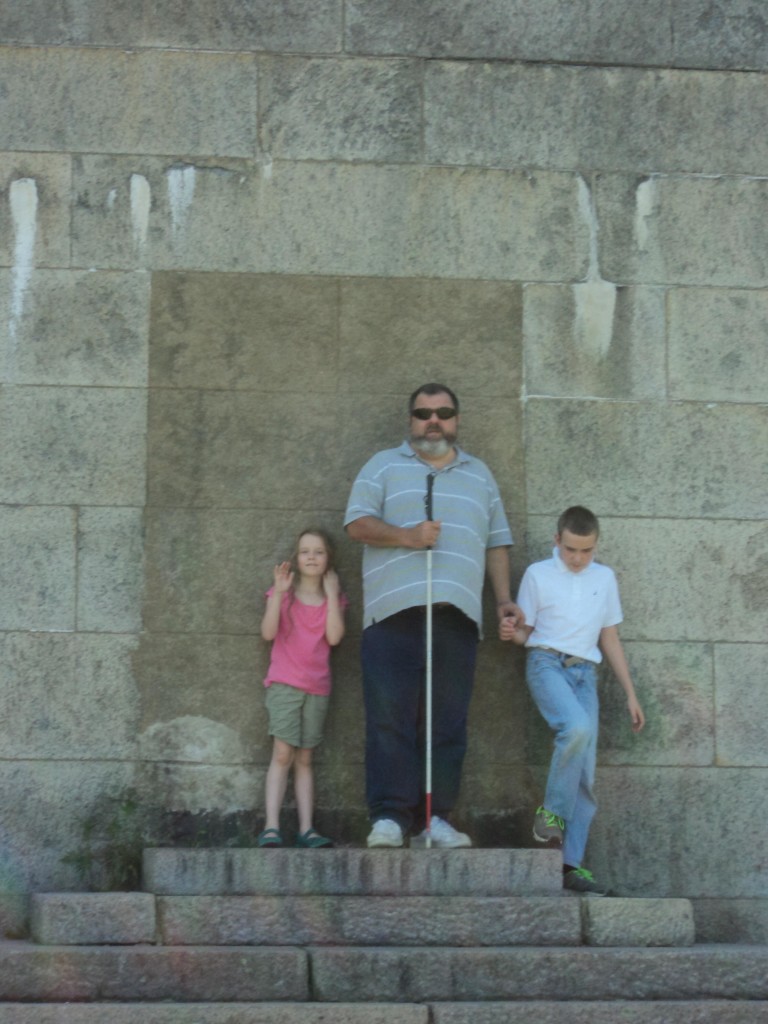 K, Warren and M on a stone wall