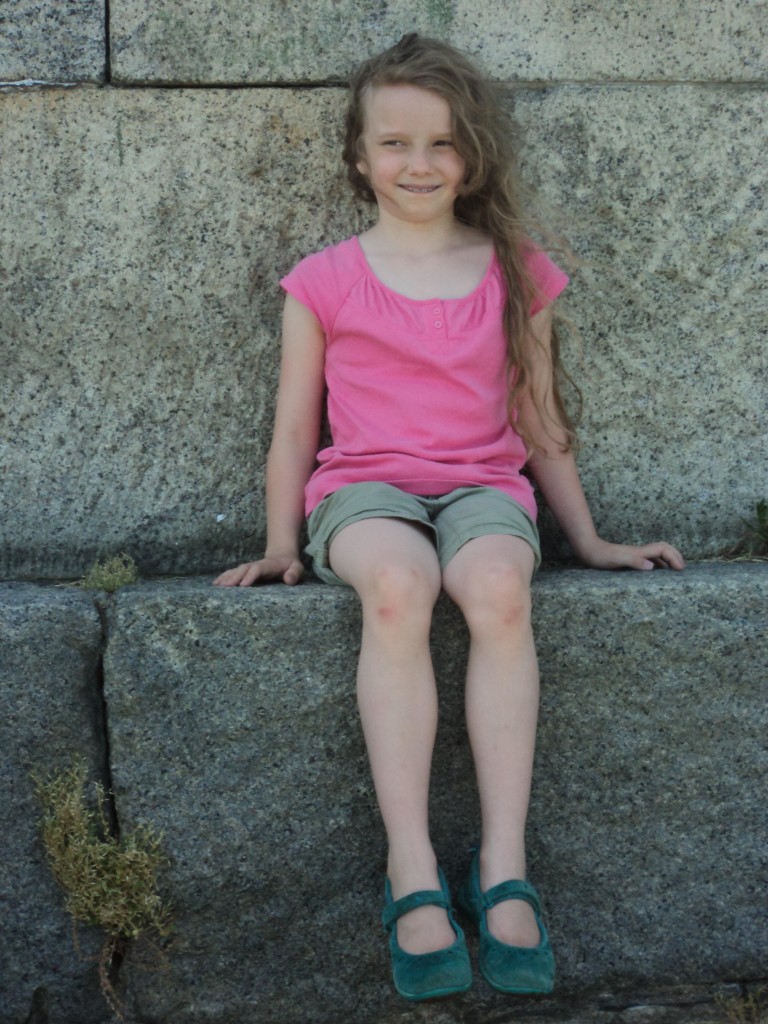 K sitting on a stone wall