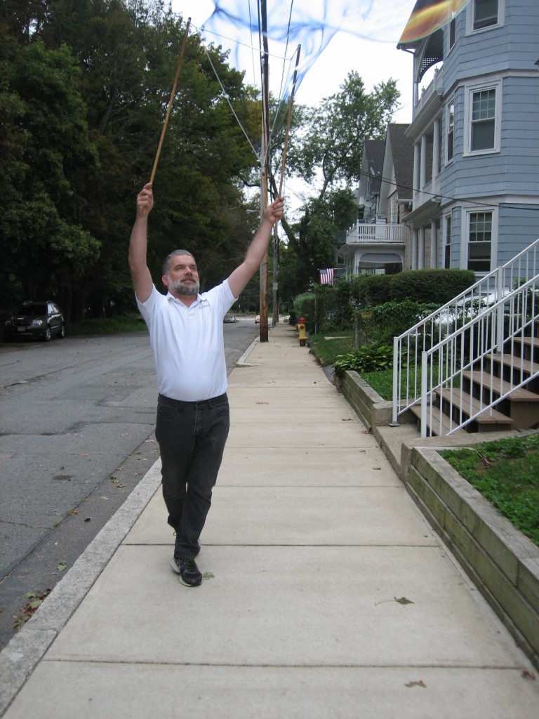 Dan waving a bubble on the sidewalk