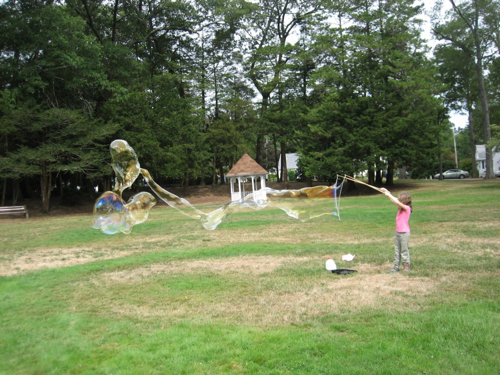 K waving bubbles in the park