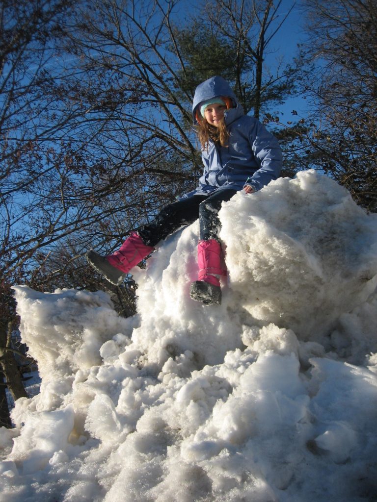 K sitting on a huge snowpile