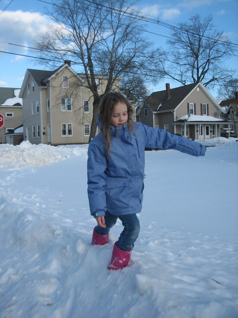 K walking through a snowbank. She calls this photo "Walking on the Himalayas"