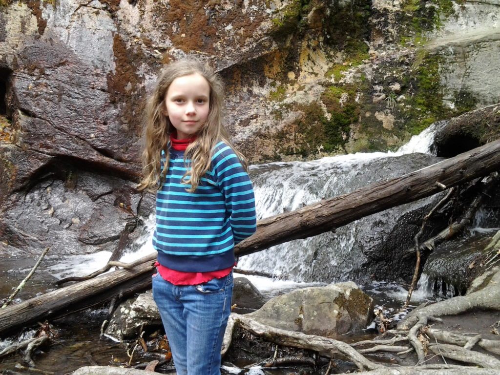 K in front of a mossy rock