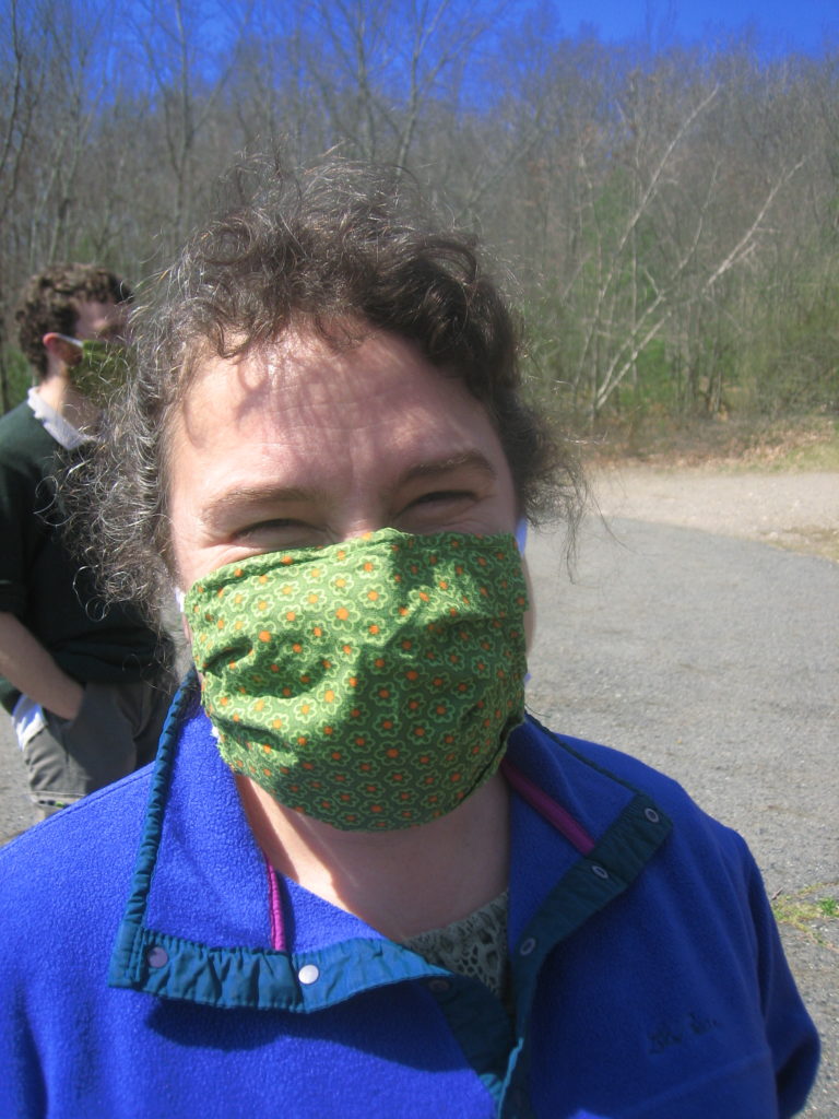 Christine wearing a green facemask on tarmak of dam