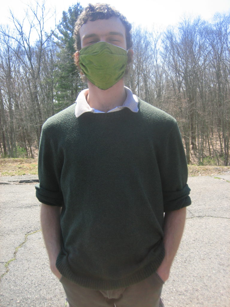 Ben, wearing a green face mask on tarmak of dam