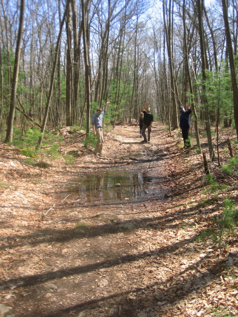 family waving from other side of muddy path