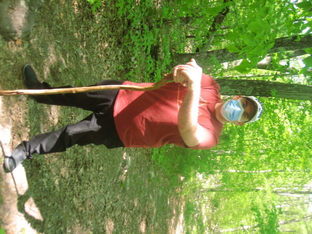 our friend Kevin iin a green May path with his favorite walking stick and a face mask