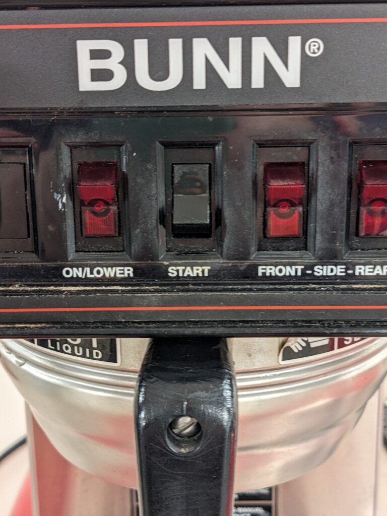 Basket of coffee machine partially pulled out, with buttons